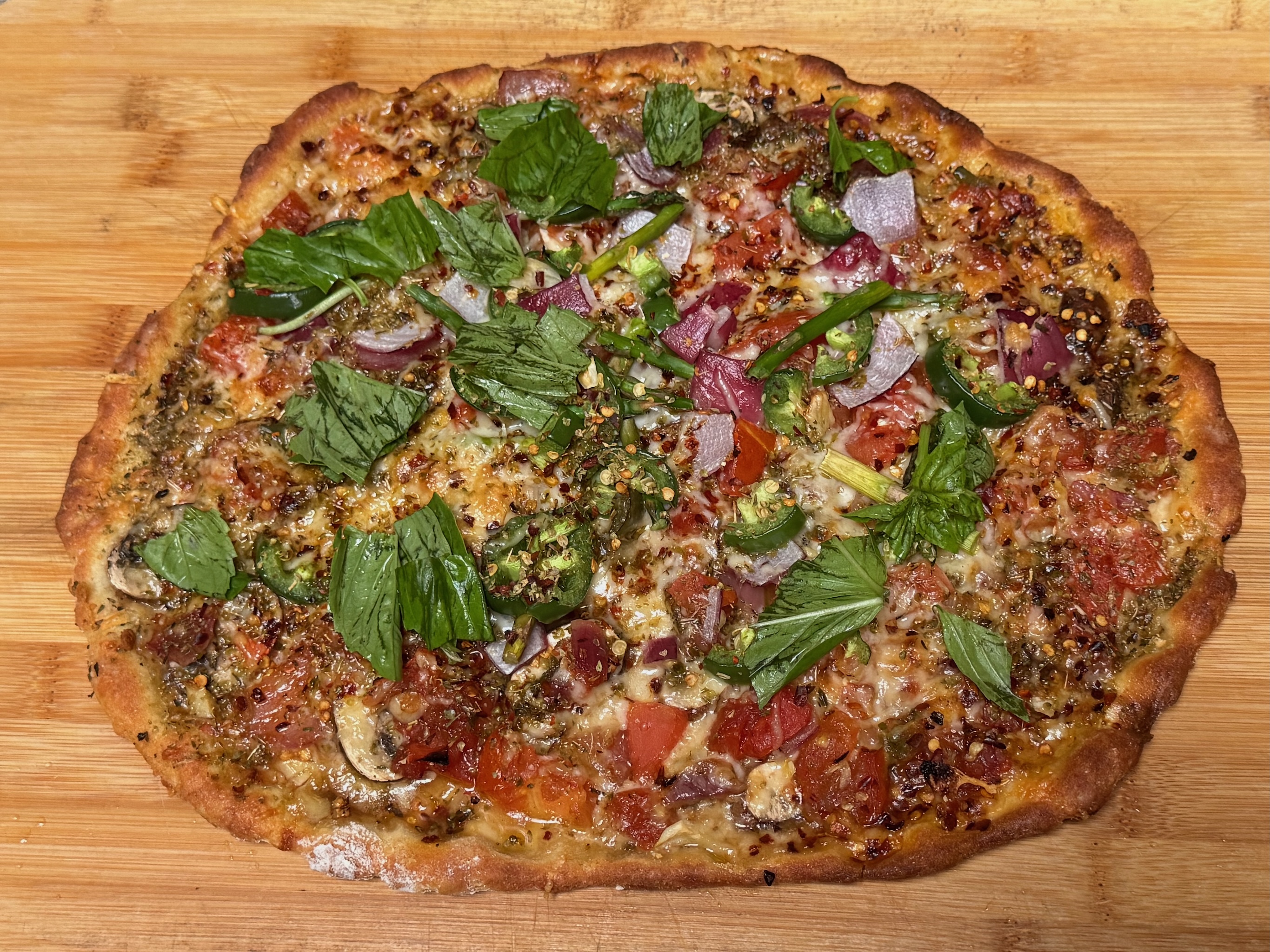 Pizza with peppers, red onions, basil, asparagus, cheese and basil